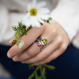 A stack of four Peridot Storybook rings in sterling silver and 9ct gold, featuring oval, diamond, round and marquise-cut gemstones, by Alison Moore Designs