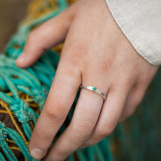 Emerald Tess storybook ring birthstone ring of May on hand with fishing net in background