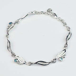 Silver bracelet with gemstones on a light gray background