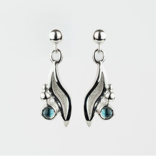 Silver earrings with blue gemstones on a white background