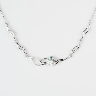 Silver necklace with a central gemstone on a white background