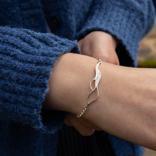 Sterling silver Tideline Bracelet by Alison Moore Designs, handcrafted in Orkney. Modelled to show the close up wave details and chain. 