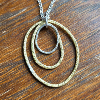 Necklace with interlocking rings on a wooden surface